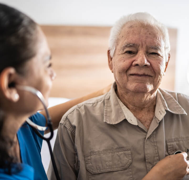 Portrait of nurse listening senior heartbeat.