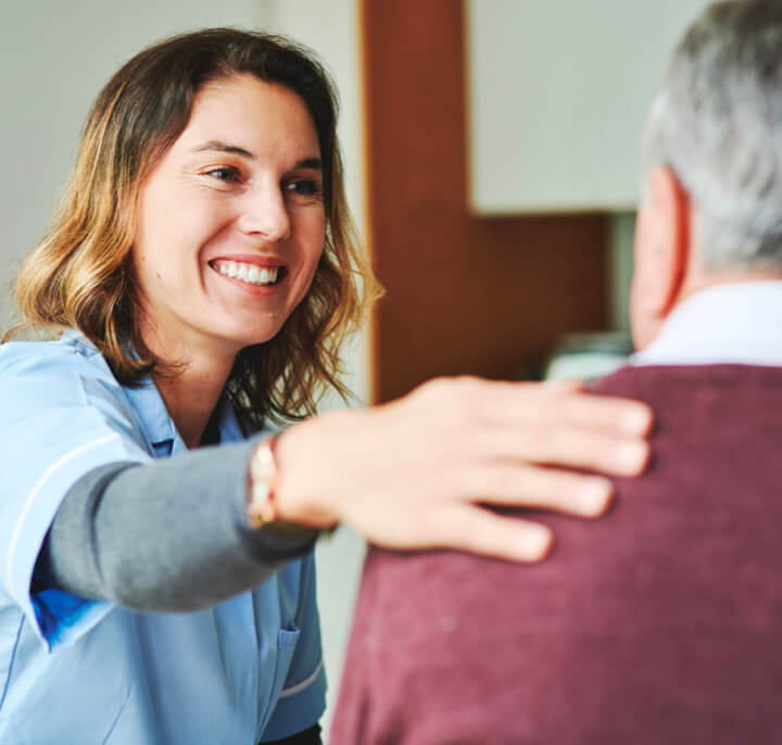 Nurse with hand on patient's shoulder.